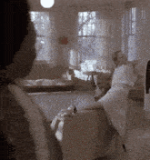 a woman in a white robe sits on a couch