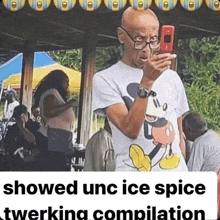 a man wearing a mickey mouse shirt is taking a picture with his cell phone