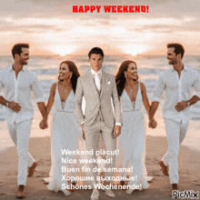 a man in a suit is standing on a beach holding hands with two women