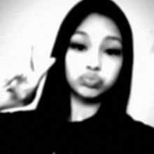 a black and white photo of a woman in a hooded jacket .