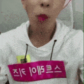 a close up of a person 's face with a pink name tag that says ' j ' on it