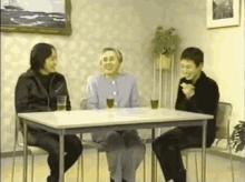 a group of people are sitting at a table with glasses of water .