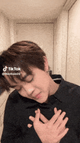 a tiktok video of a young man with his hands on his chest is being uploaded by thiothaio20