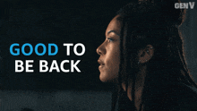 a woman with dreadlocks is standing in front of a sign that says " good to be back "