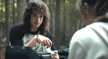 a man with long curly hair wearing a shirt that says ufc on it