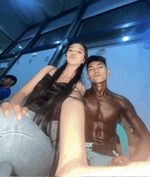 a man and a woman pose for a picture with the man 's shirt off