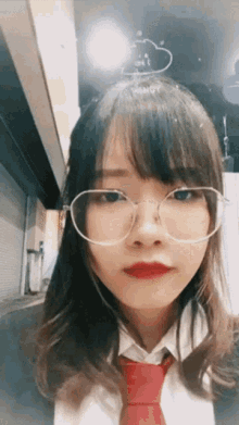 a girl wearing glasses and a red tie has a cloud on her head