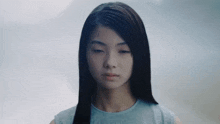 a close up of a girl 's face with a blue shirt on