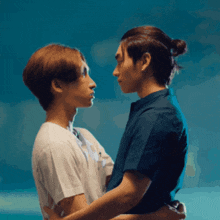 two men are hugging each other and looking into each other 's eyes