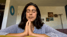 a woman is praying with her eyes closed