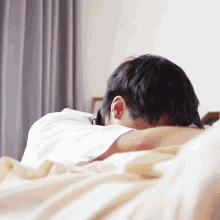a person laying on a bed with their head down