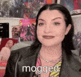 a woman wearing a black leather jacket and a chain necklace says mogged .