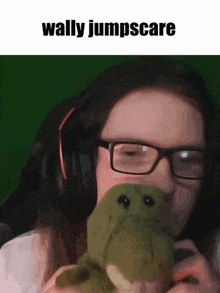 a girl with glasses is holding a stuffed frog and says wally jumpscare on the bottom