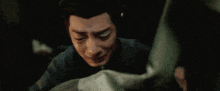 a close up of a man 's face with a hand on his face .