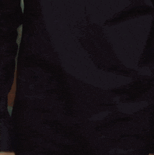 a close up of a man 's face wearing a black jacket and looking at the camera .