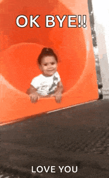 a little girl is sitting on top of an orange slide with the words `` ok bye ! ''