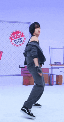 a person standing in front of a sign that says " stop do not enter "