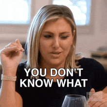 a woman sitting at a table with a glass of wine says " you don t know what "