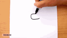 a person is drawing a letter c with a black marker