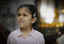 a little girl is making a funny face in front of a sign that says ' one night stand '