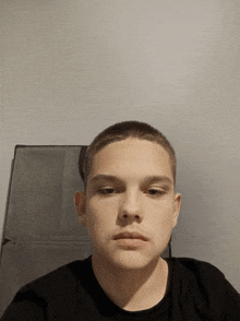 a young man with a shaved head is looking at the camera