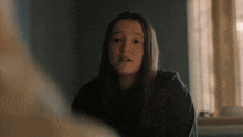 a girl with long hair is looking at the camera