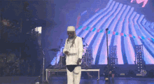 a man wearing a white shirt that says noopy on it is dancing on a stage