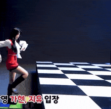 a woman in a red dress is dancing on a checkered floor with chinese writing