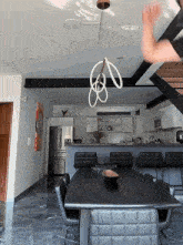 a dining room with a black table and chairs and a stainless steel refrigerator
