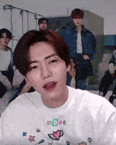 a man wearing a white shirt that says mdme on it
