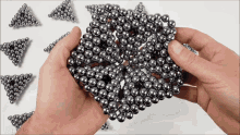 a person is holding a bunch of metal beads in their hands