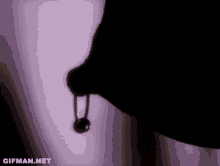 a purple background with a shadow of a person holding a ring .