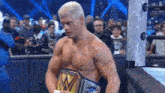 a shirtless wrestler is holding a world heavyweight championship belt in a wrestling ring .