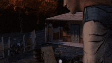 a man in a video game is standing in front of a house with a sign that says ' a ' on it