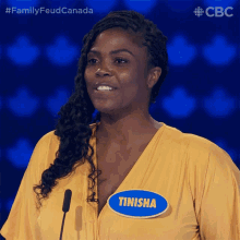 a woman in a yellow shirt with a name tag that says finisha