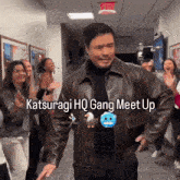 a man in a leather jacket is dancing in a hallway with the words " katsuragi hq gang meet up " on the bottom