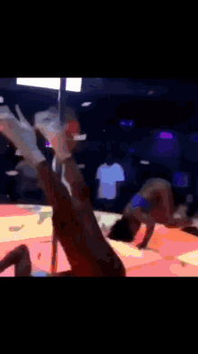 a man is dancing on a pole in a club