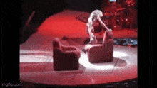a woman is sitting on a chair on a stage .