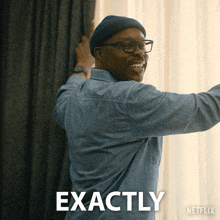 a man in a denim shirt is smiling in front of a netflix ad