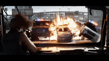 a billboard that says fun is no borders is behind a car on fire