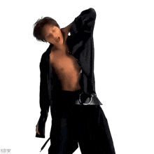 a shirtless man in a black jacket is dancing .