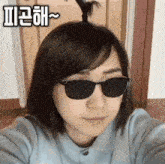 a woman wearing sunglasses is taking a selfie .