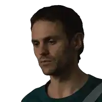a man with a beard wearing a blue shirt looks down