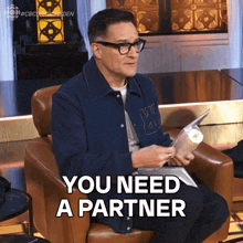 a man sitting in a chair with the words you need a partner on the bottom