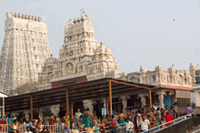 a crowd of people are gathered in front of a temple