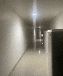 a dark hallway with a light on the ceiling