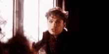 a man is standing in front of a window with a broken glass .