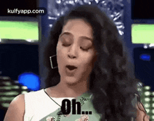 a woman with her eyes closed is making a funny face and saying `` oh '' .