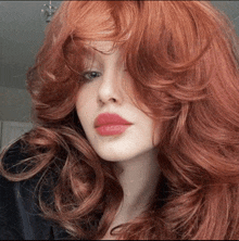 a woman with long red hair and red lips