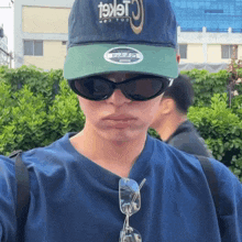 a person wearing sunglasses and a hat that says ' cricket ' on it